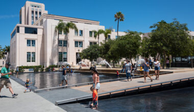 Photo of unidentified mother and son enjoying a warm summer day in the fountain at Waterfront Park in front of a County Administrative Building.