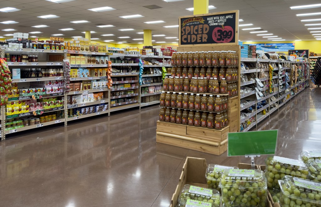 A display of Trader Joe's Spiced Cider bottles in a grocery store aisle.