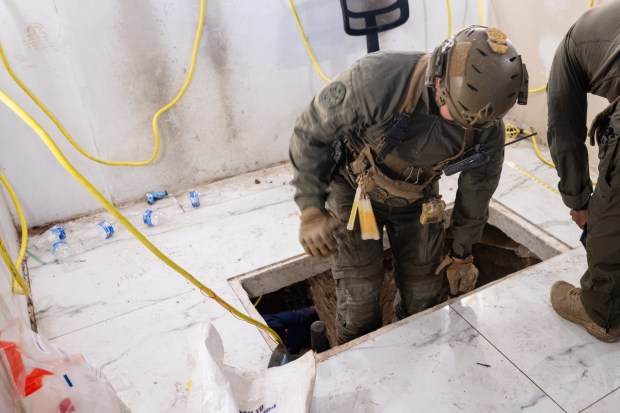 A U.S. border agent accesses the exit of a cross-border tunnel that ends in an Otay Mesa business. (U.S. Customs and Border Protection)