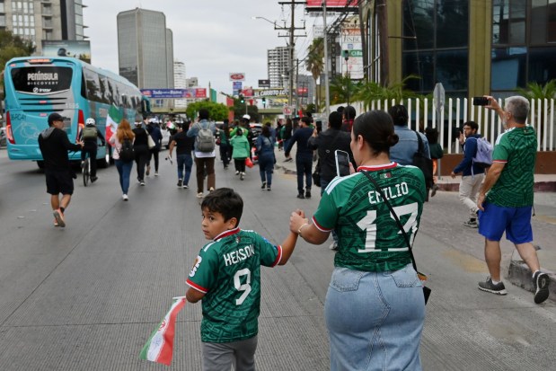 Fans cheer and chase the bus carrying Iran's players as they leave the Marriott Hotel at their Tijuana base camp to the airport ahead of the Iran National Team's departure following its elimination from the 2026 World Cup football tournament in Tijuana, Mexico on Tuesday, June 30, 2026. (Carlos Moreno / The San Diego Union-Tribune)