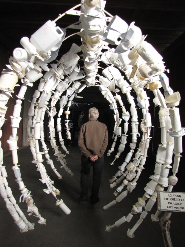 A man walks through a whale's rib cage sculpture created entirely from ocean debris in "Washed Ashore: Art to Save the Sea," opening today at the San Diego Natural History Museum. (Washed Ashore Project)
