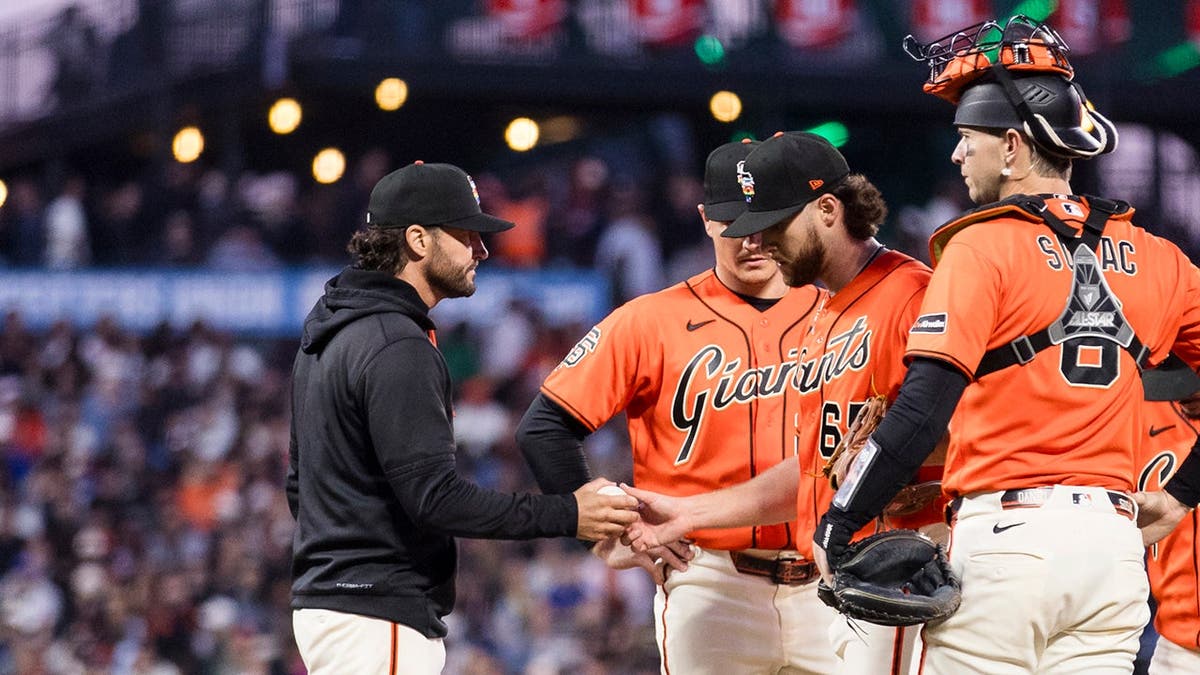San Francisco Giants manager Tony Vitello lifting starting pitcher Landen Roupp at Oracle Park.