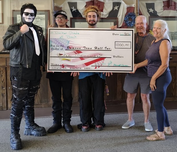 From left, Brando Duran, Brian Hock and Kia Rooei, members of the Darker Shade of Black band, present a $1,000 check for Ramona Town Hall renovations to Tom McKelvey and Jill Bacorn. The band raised the money at the June 13 Headbangers Ball concert. (Courtesy Garrett Wear)