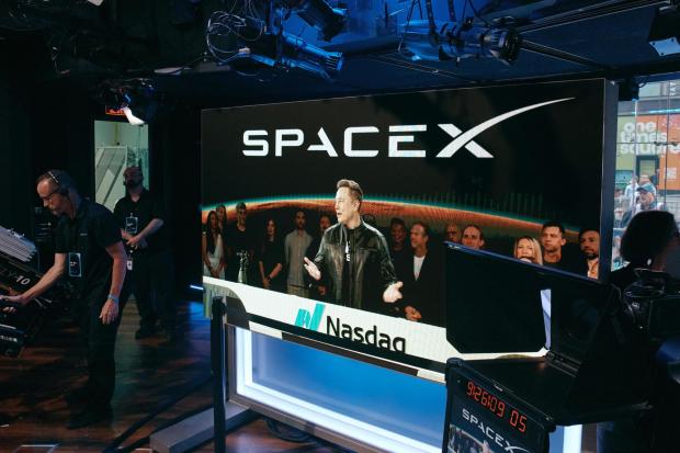 Elon Musk is visible on a video feed from Starbase, the Texas headquarters of SpaceX, at the Nasdaq stock exchange in New York on Friday morning, June 12, 2026. Musk became the world's first trillionaire on June 11, 2026, as shares of his rocket company SpaceX began trading on the stock market at $150, up 11 percent from their initial public offering price. (Andres Kudacki/The New York Times) 