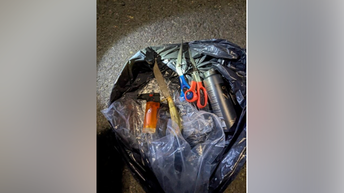 Knife, scissors, lighter and other items displayed in an evidence photo from a federal criminal complaint