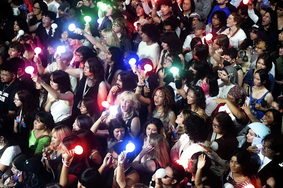 Fans carry LED glowsticks that light up in sync with the artist's setlist. (Theo LaBrusciano-Carris/For SFGATE)