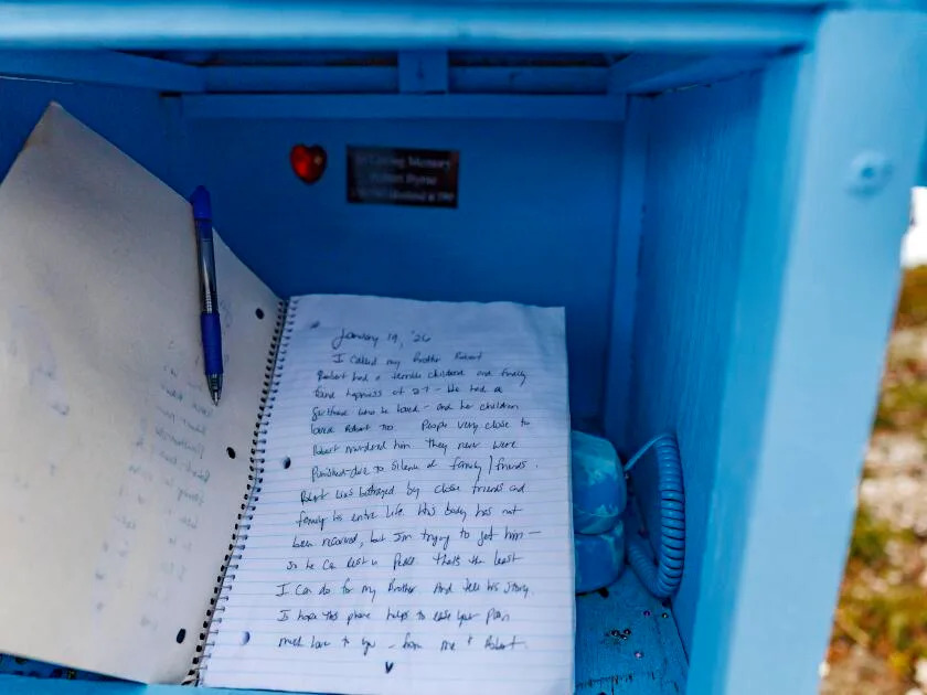 A notebook filled with personal tributes lays inside the wind phone structure.