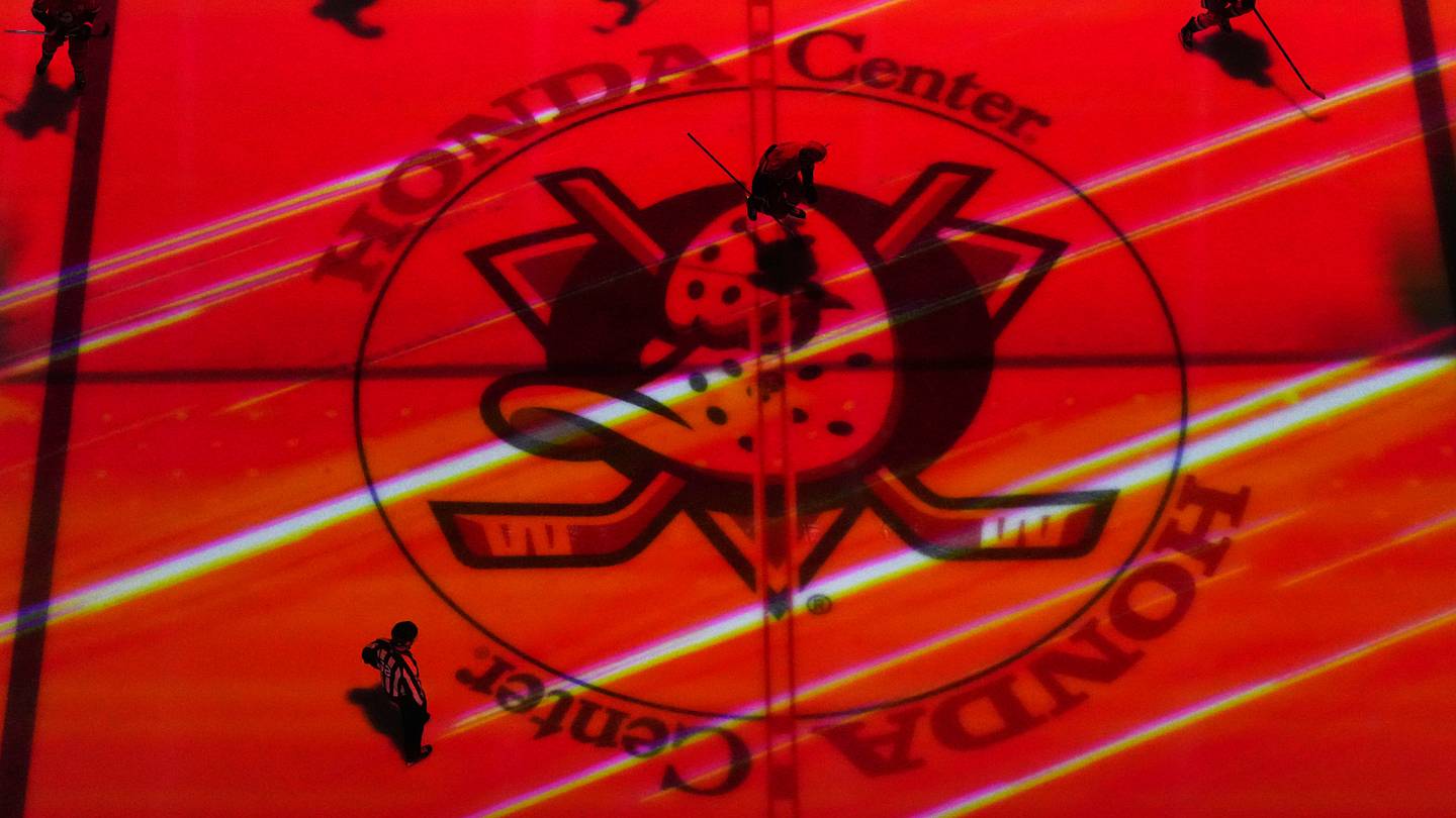 Apr 13, 2025; Anaheim, California, USA; Colorado Avalanche and Anaheim Ducks players skate across the Ducks logo at center ice in the second period at Honda Center. Mandatory Credit: Kirby Lee-Imagn Images