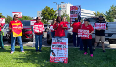 Nurses outside holding signs calling a halt of burn unit closure