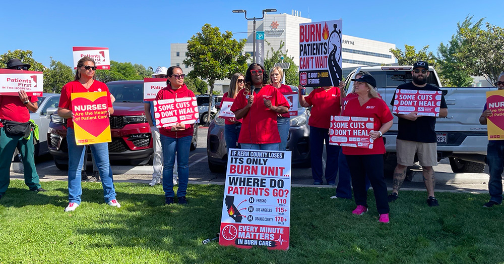 Nurses outside holding signs calling a halt of burn unit closure
