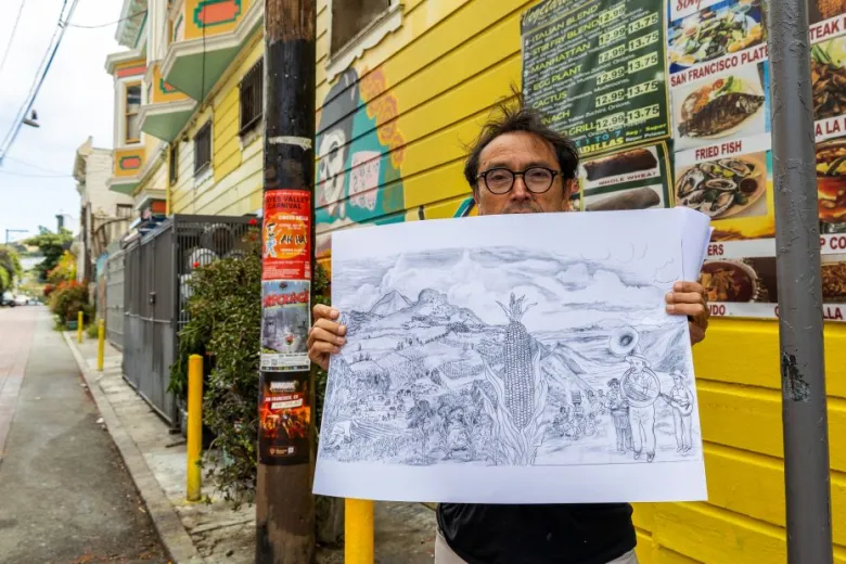 A man stands on a city sidewalk holding a large pencil drawing in front of a yellow wall with restaurant menus and a utility pole.