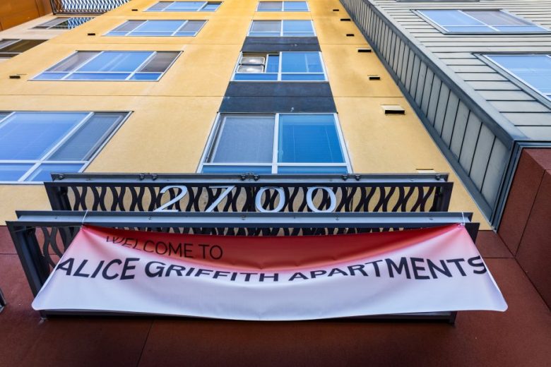 A red and white banner reads “Welcome to Alice Griffith Apartments” below the address number 2700 on a modern apartment building.