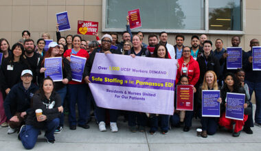 Group of nurses and physicians outside hospital holding banner "UCSF Workers Demand Safe Staffing"
