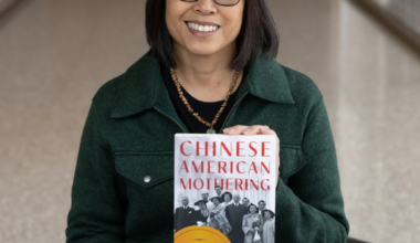 Dr. Andrea Louie smiles holding her book