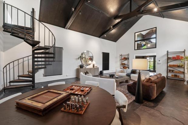 Great room with high ceiling and iron staircase.