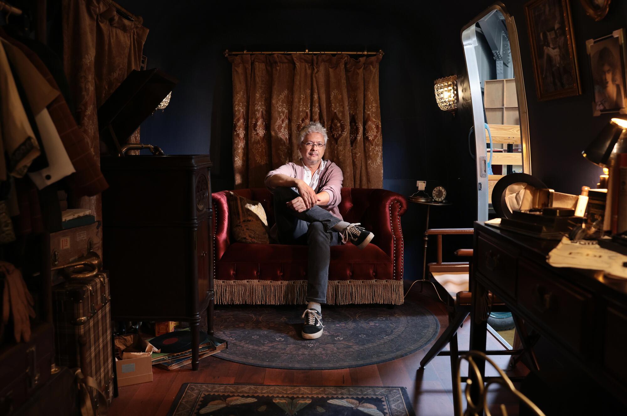 A man sits in an old-school studio dressing room.