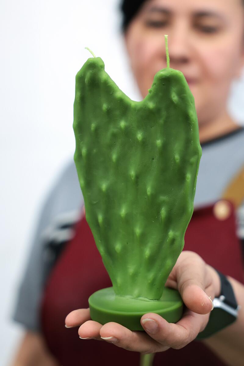 A worker holds a cactus candle 