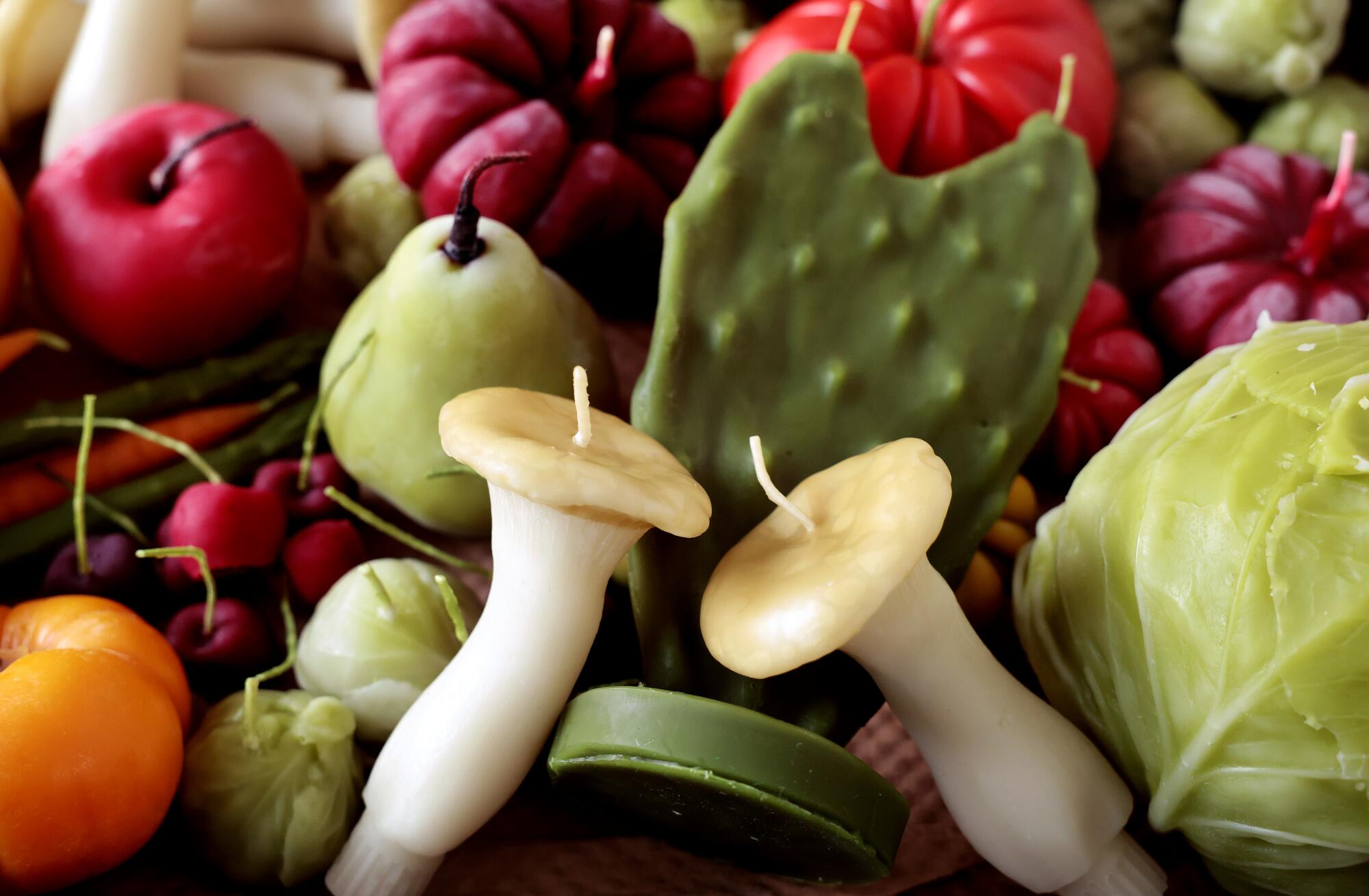 A variety of fruit and veggie candles sit on a tray at Happy Organics' studio.