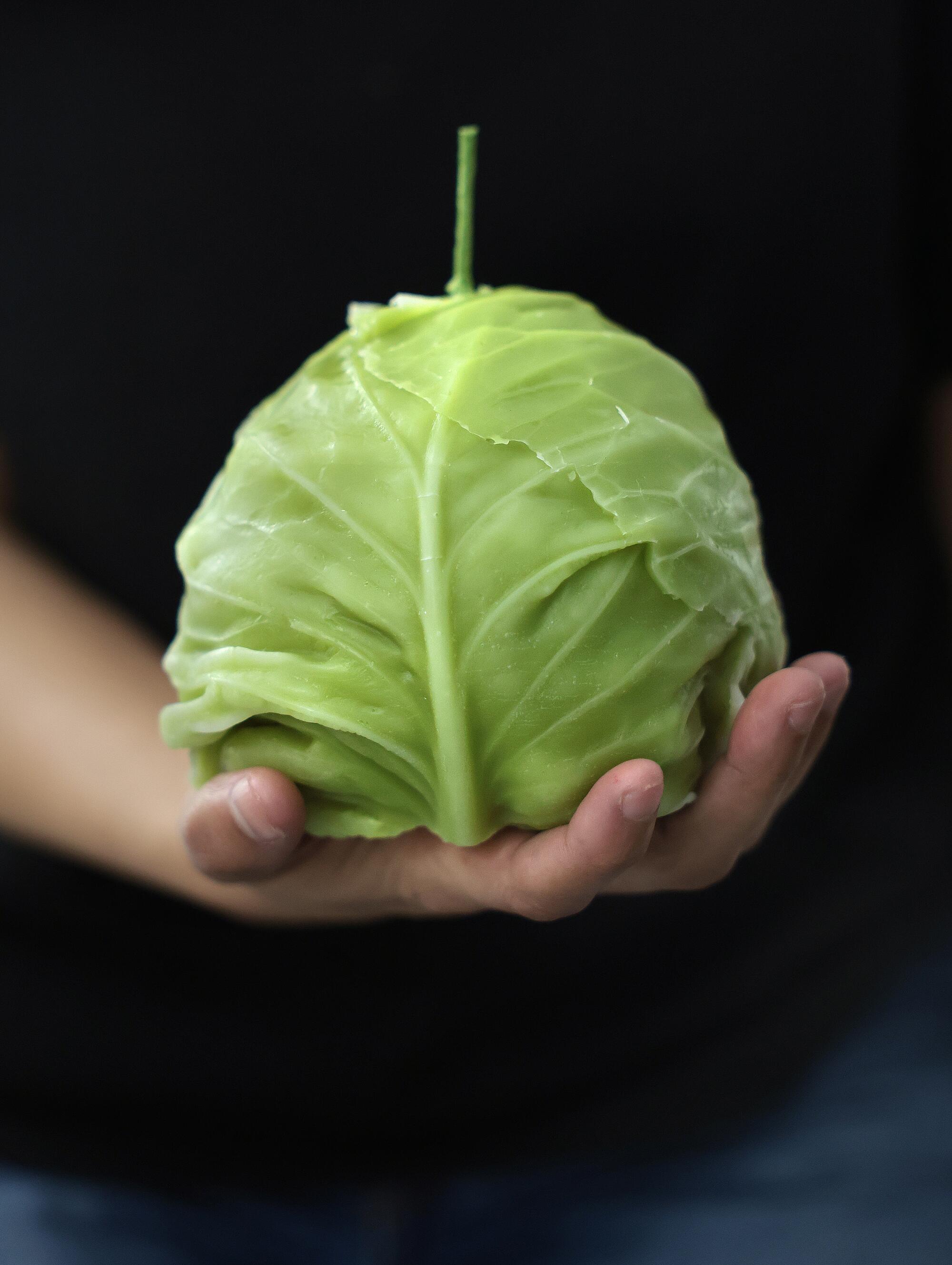 Jessica Gonzalez holds a cabbage candle.