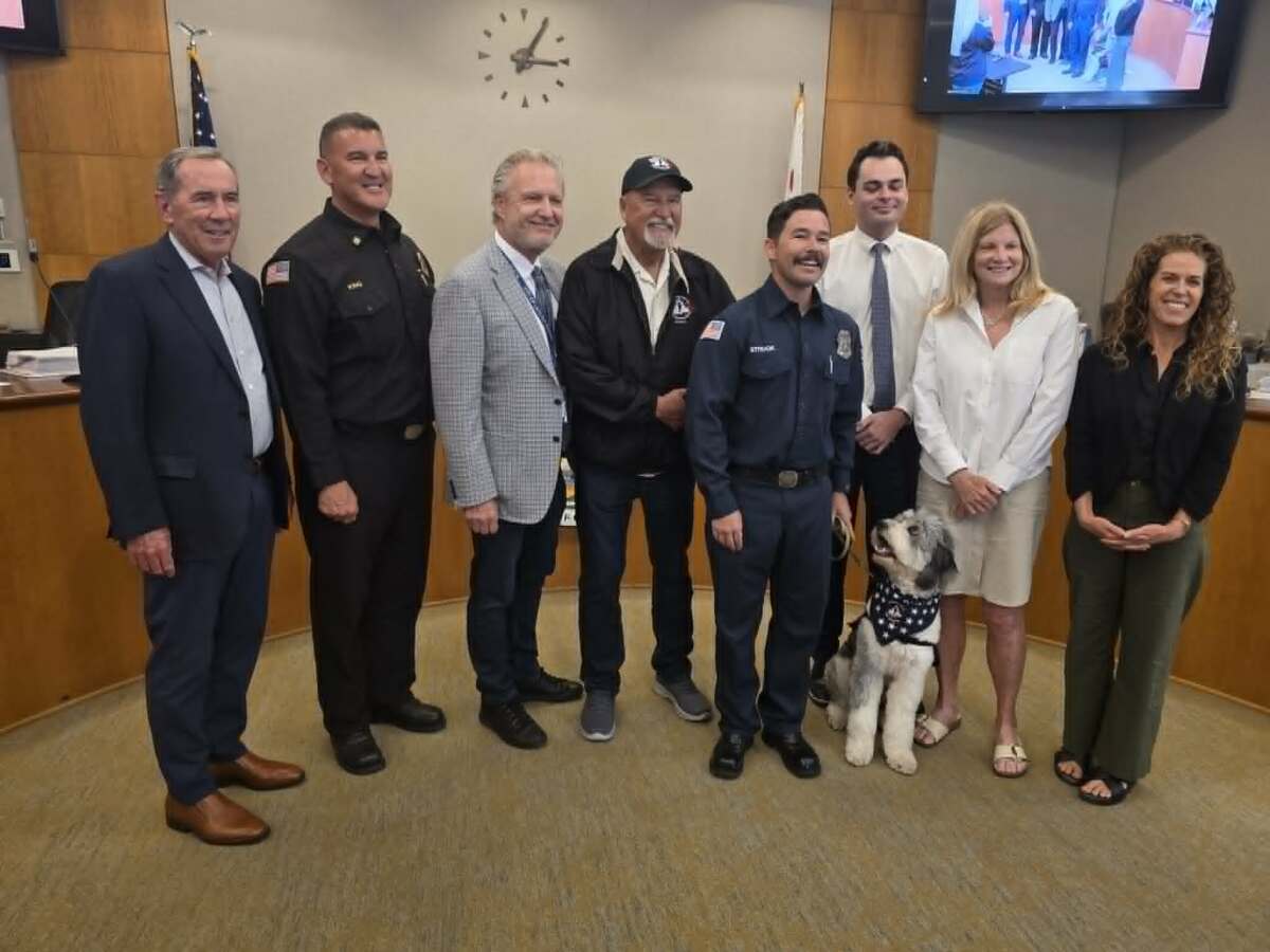 The Laguna Beach City Council joins the fire department's peer support dog, Oro, and his handler, Logan Strook, on June 23.