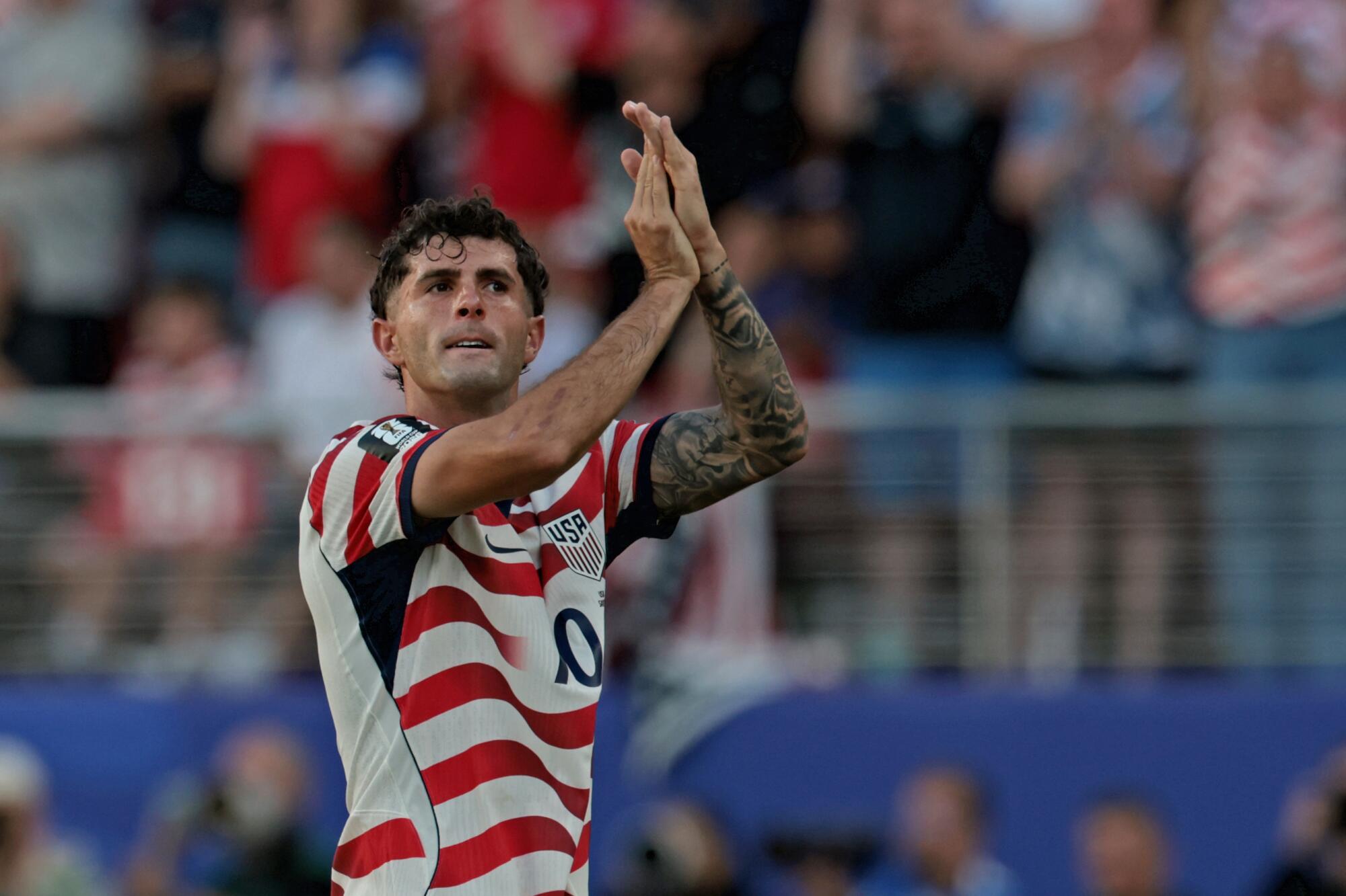 U.S. forward Christian Pulisic claps toward fans as he leaves a World Cup match against Bosnia-Herzegovina.