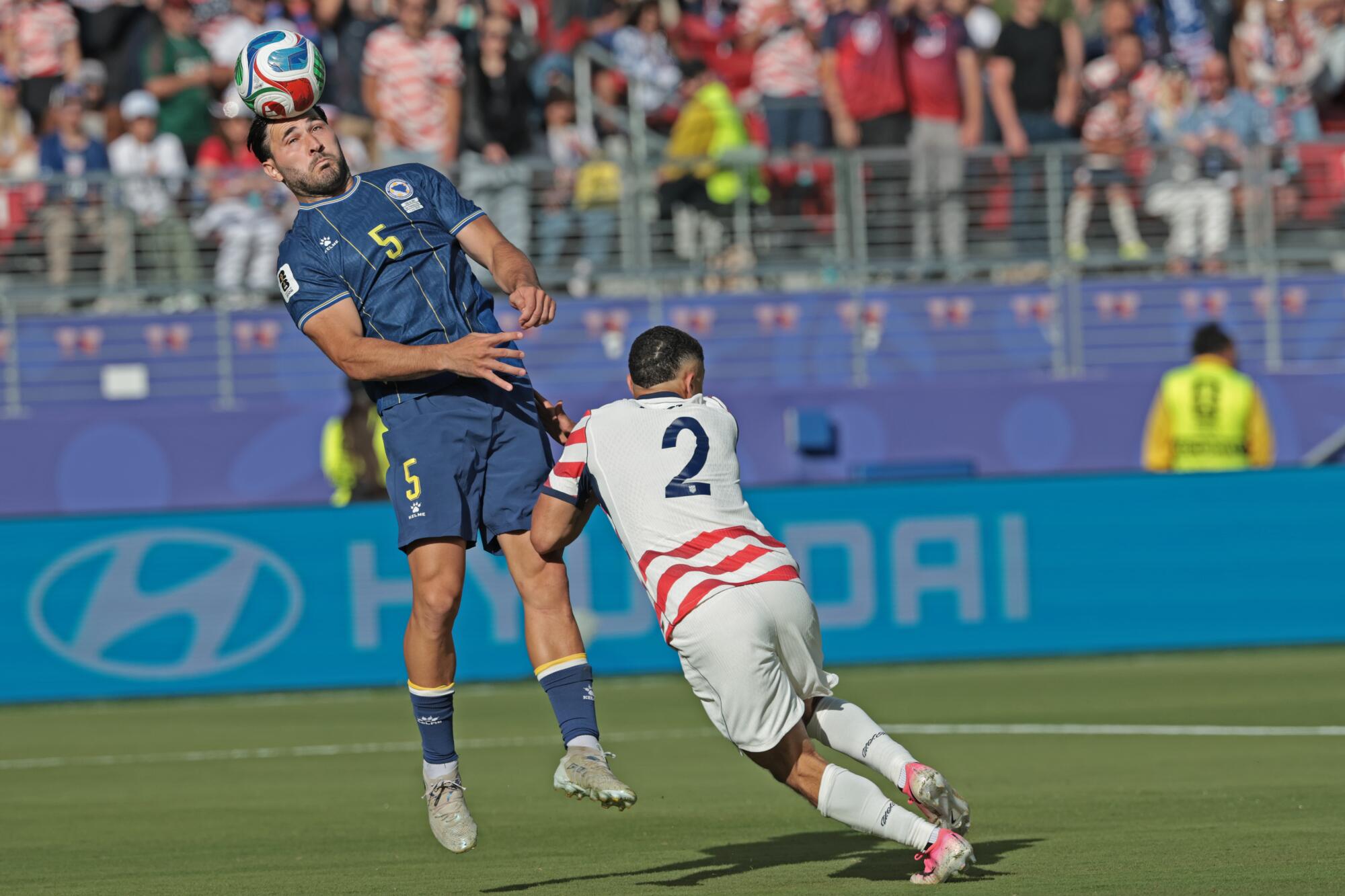 Bosnia-Herzegovina defender Sead Kolasinac heads the ball in front of U.S. defender Sergino Dest.