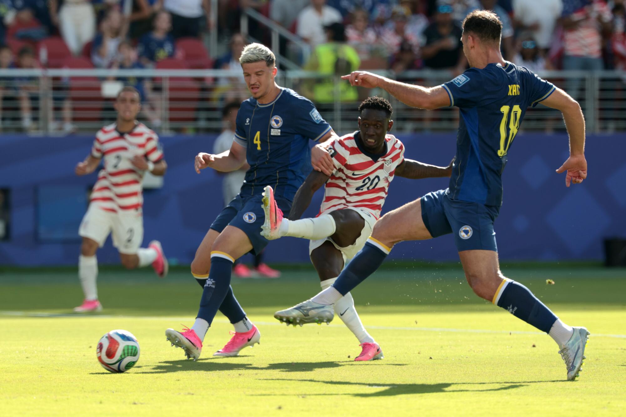 U.S. forward Folarin Balogun scores in front of Bosnia-Herzegovina defender Tarik Muharemovic and Nikola Katic.