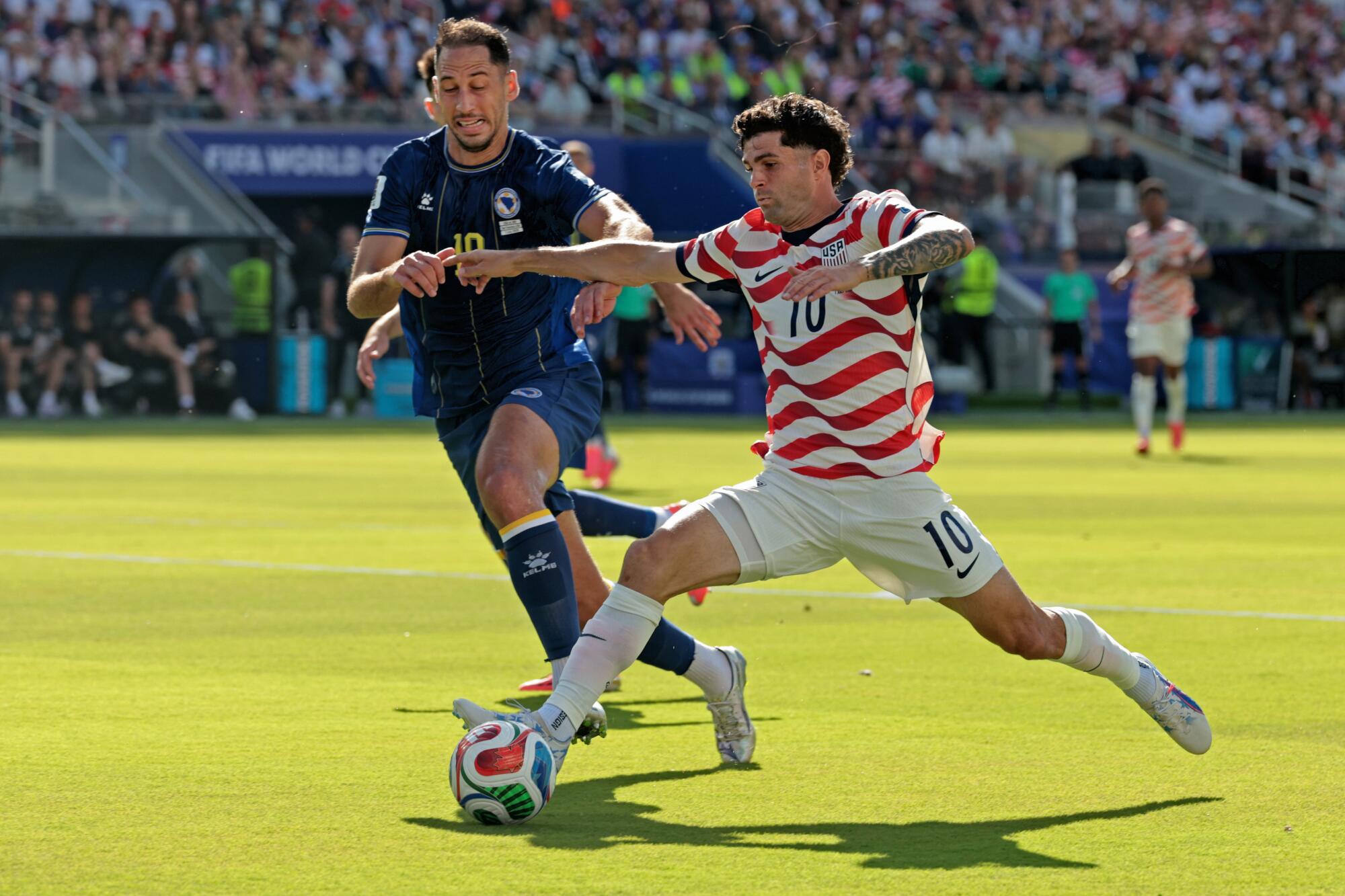 U.S. forward Christian Pulisic and Bosnia-Herzegovina defender Nikola Katic vie for the ball during a World Cup match.