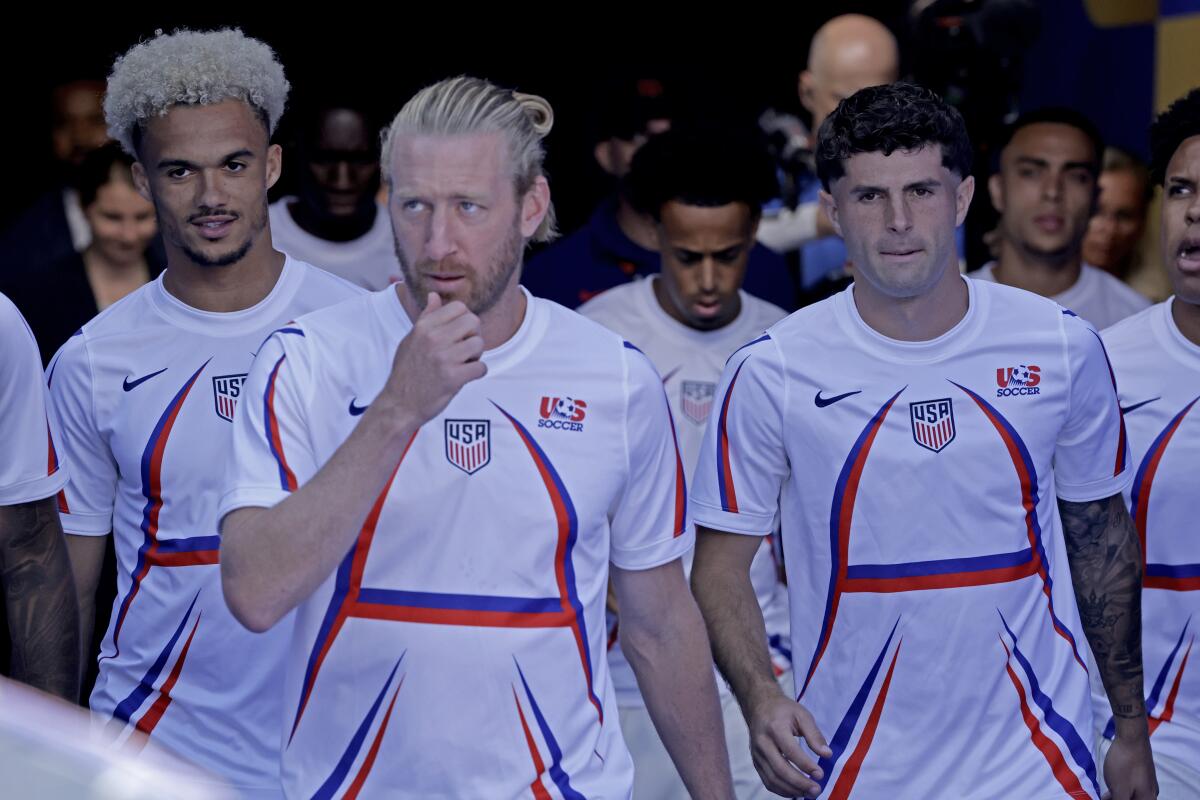 U.S. players Tim Ream, Christian Pulisic and others walk onto the Levi's Stadium field before a World Cup match.