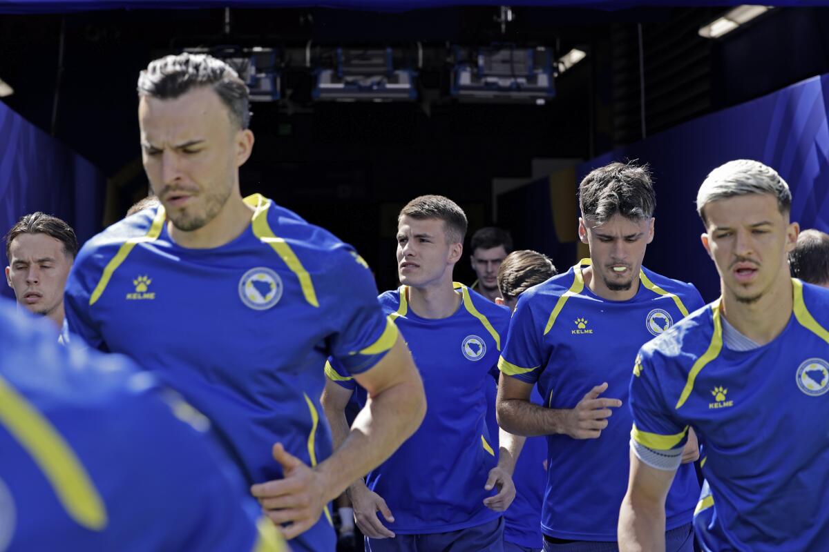 Bosnia-Herzegovina players walk onto the Levi's Stadium field before a World Cup round of 32 match.