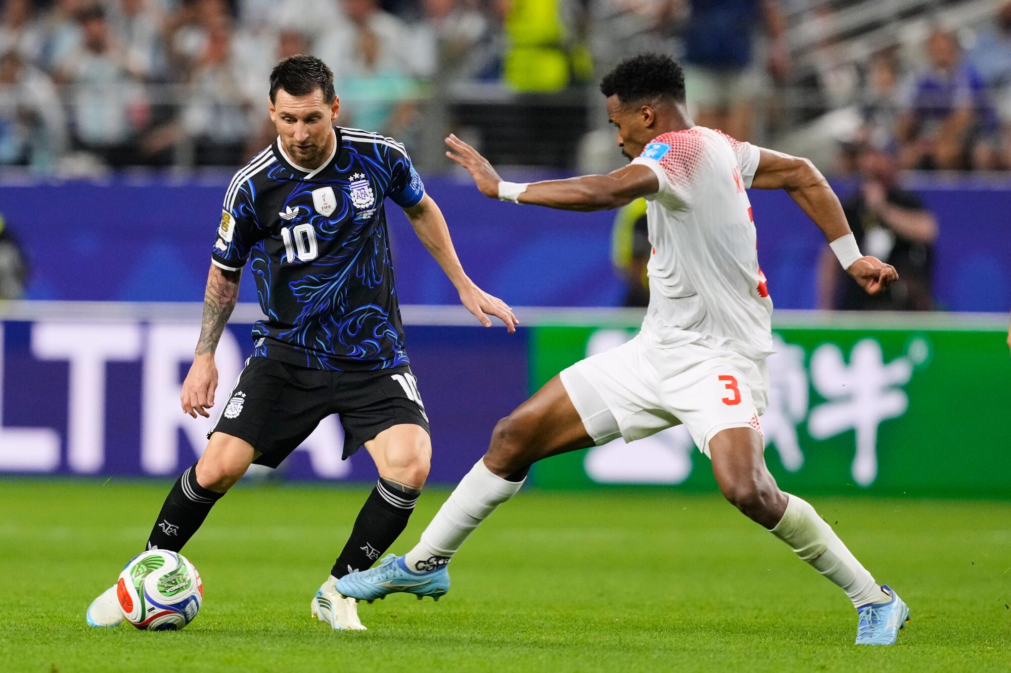 Argentina's Lionel Messi, left, and Jordan's Noussair Mazraoui battle for the ball at the World Cup on June 27.
