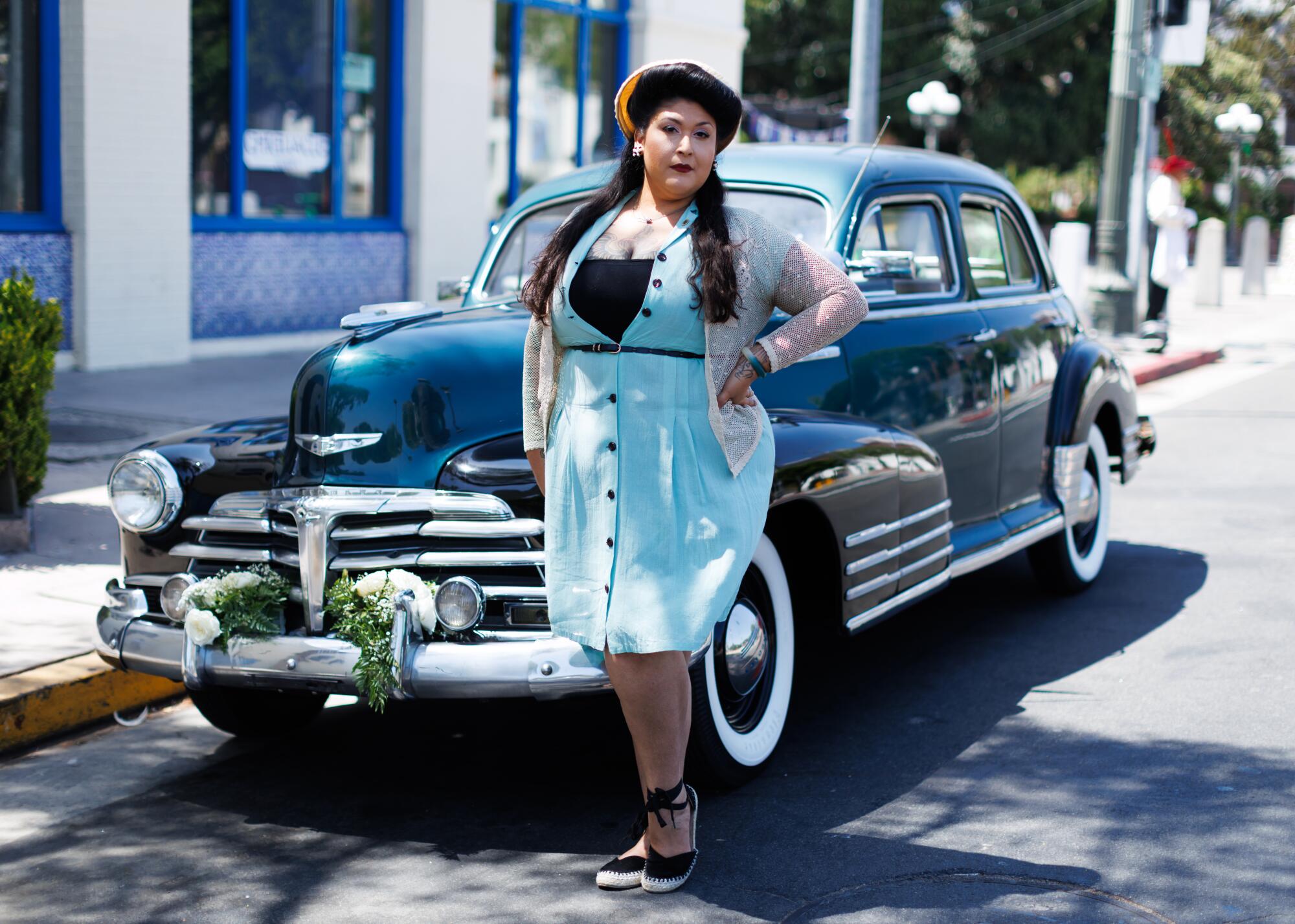 A person in front of an old-fashioned car.