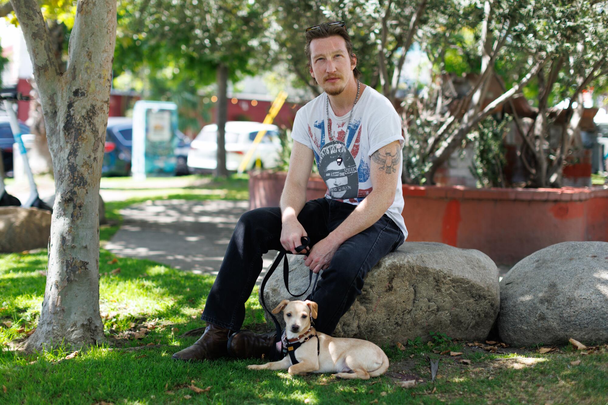 A person with their chihuahua in a park.