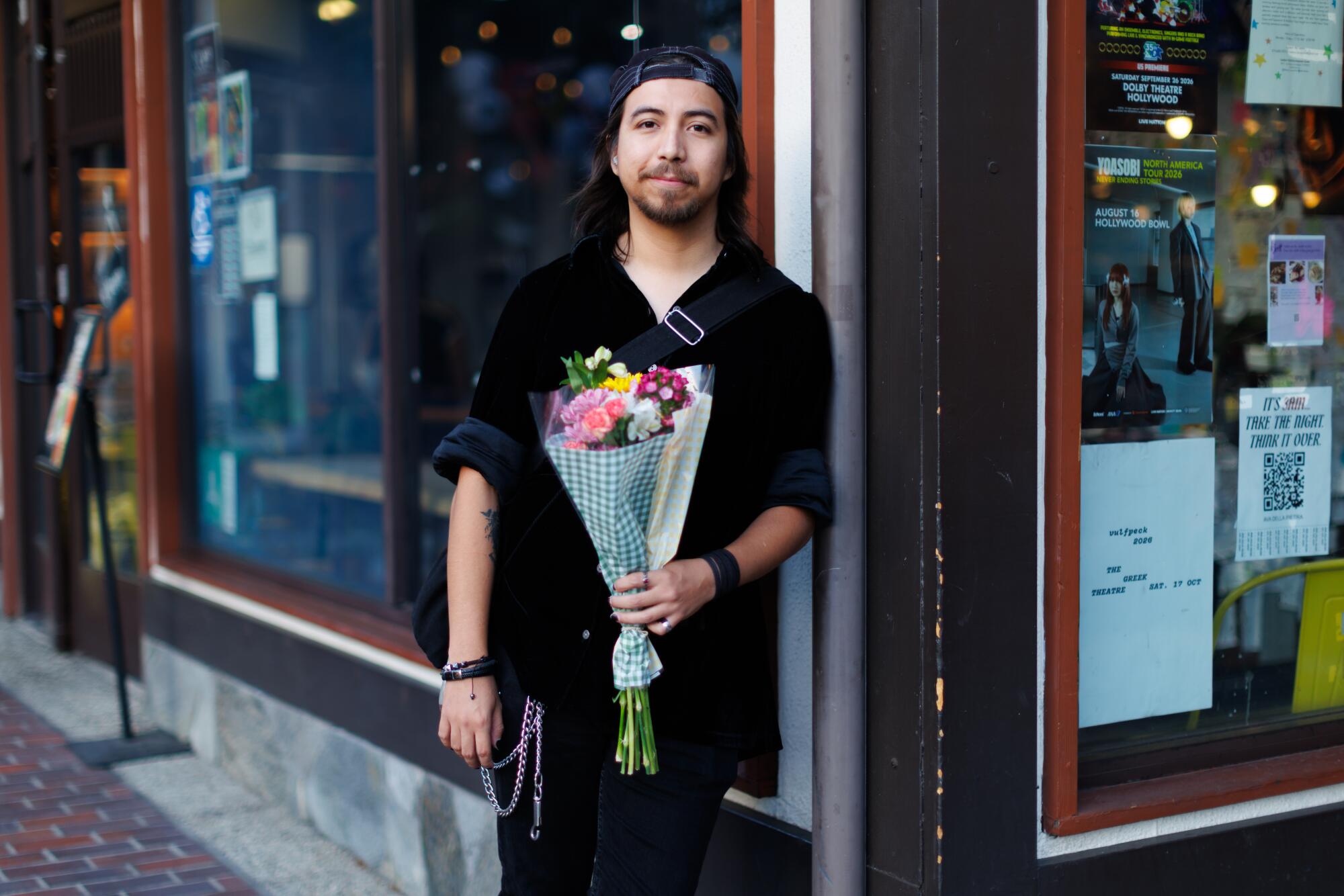 A person standing in Little Tokyo holding a bouquet of flowers.