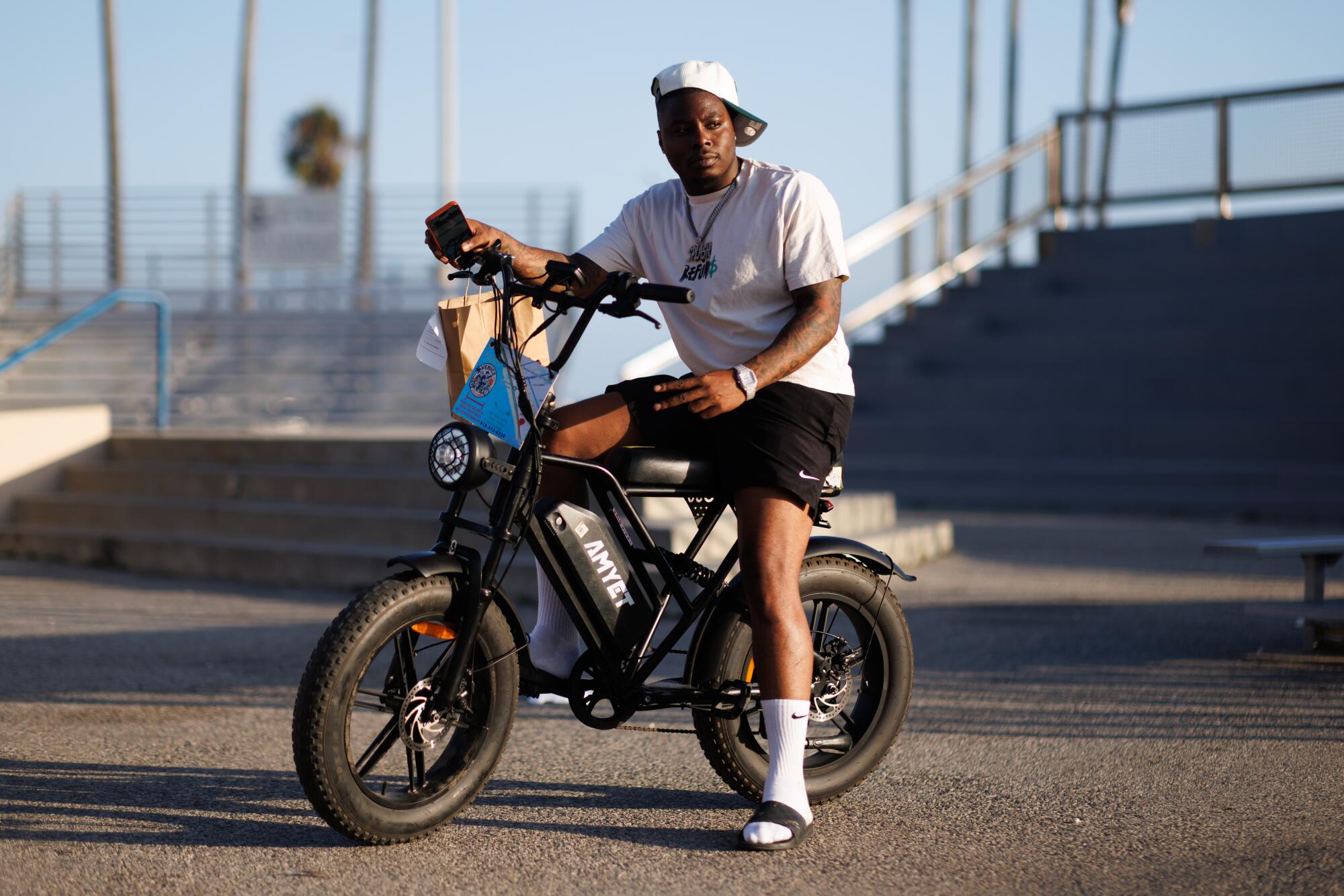 A person sits on his bike at a skate park.