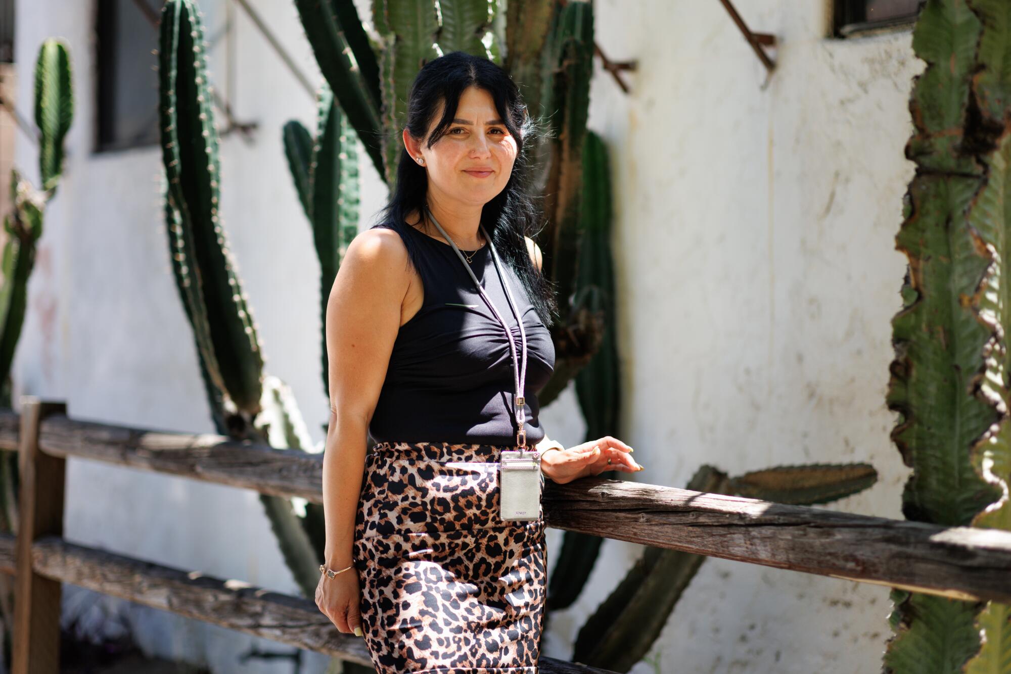 A person stands outside by a row of cacti in Little Armenia.