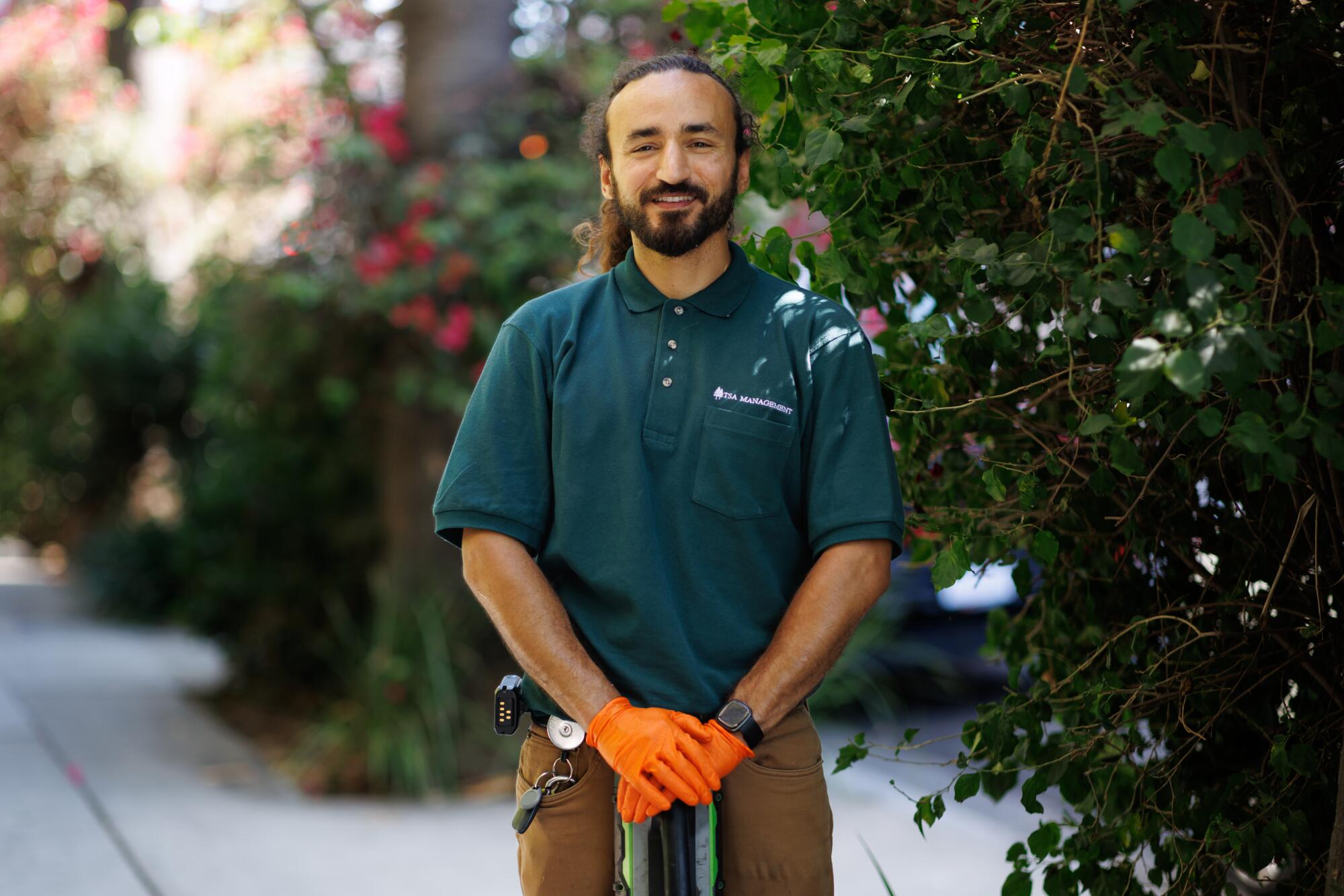 A person stands outside in a garden while landscaping.