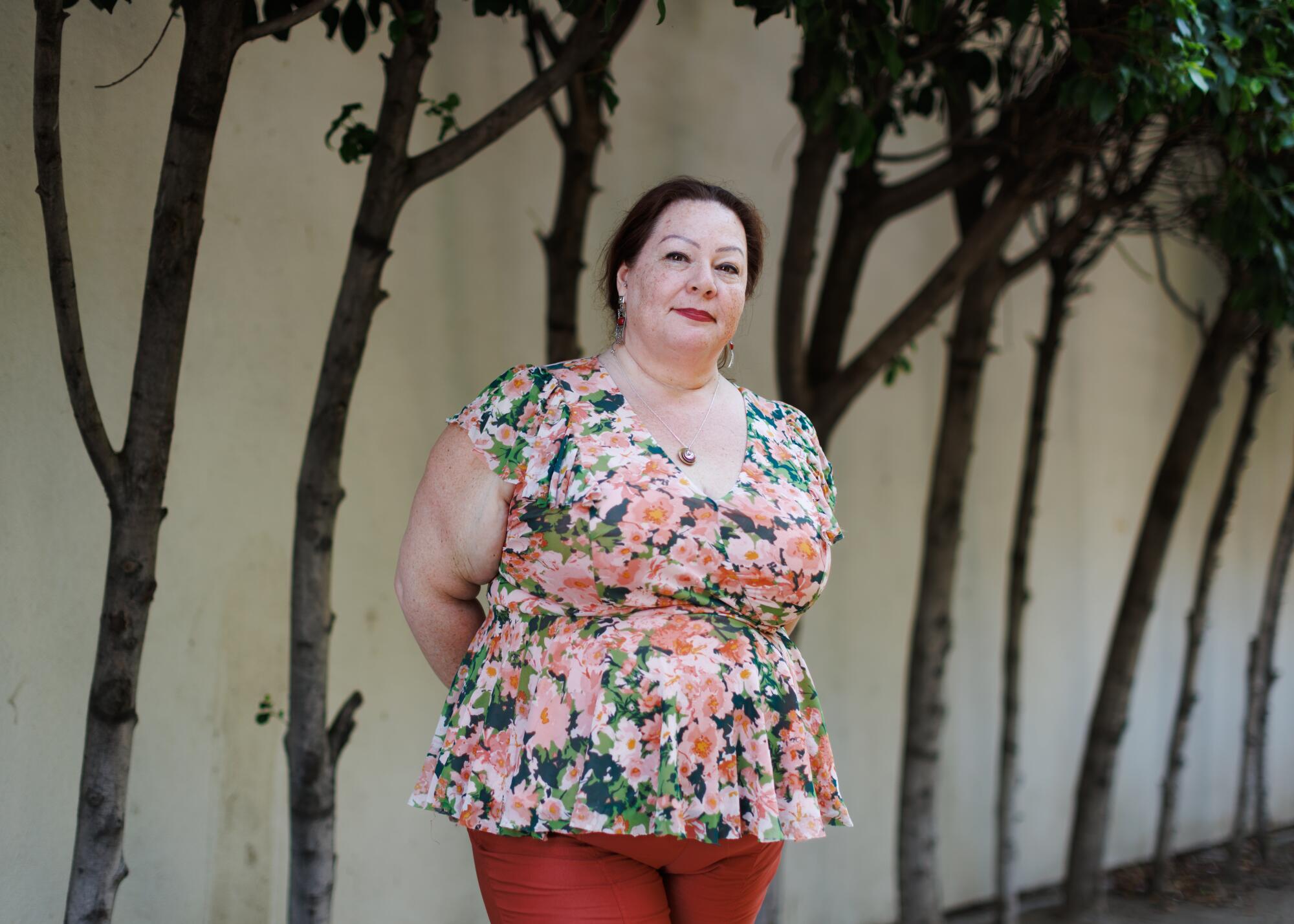 A person stands outside by a row of trees in Glendale.
