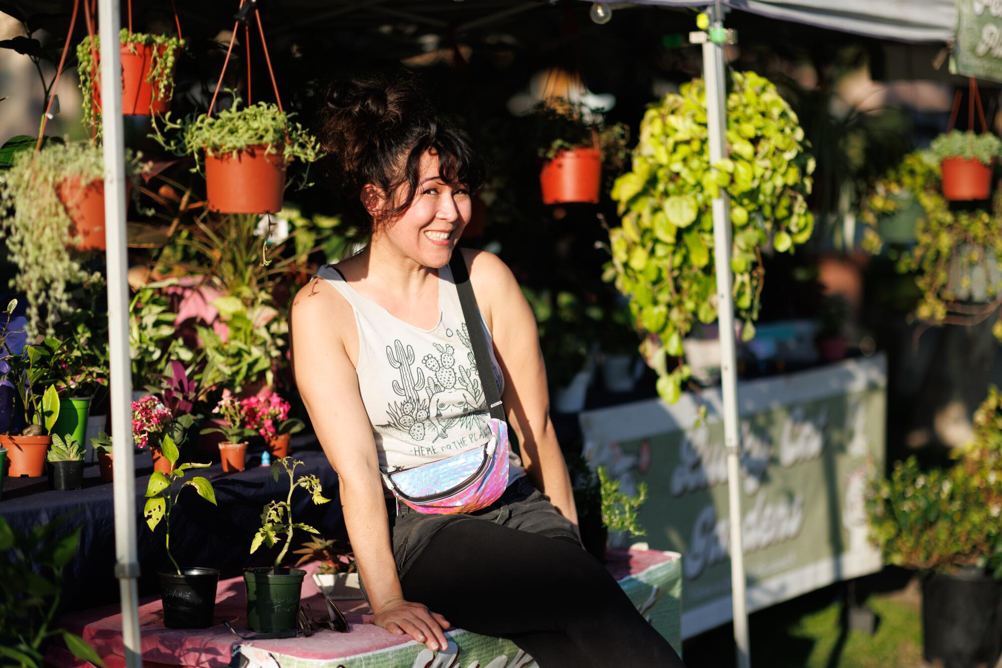 A person stands outside her plant shop.