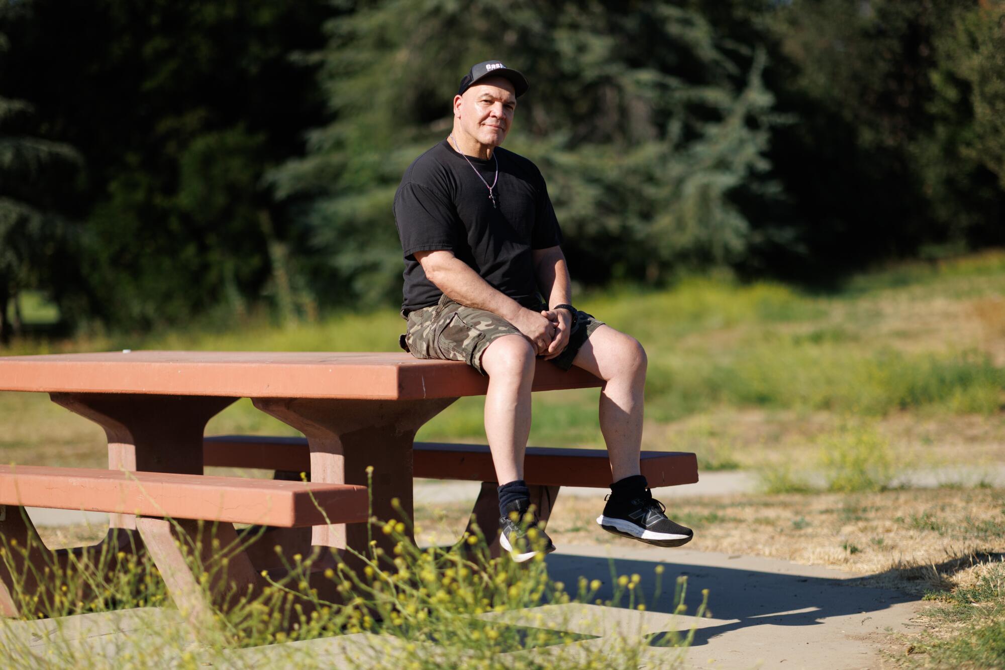 A person sitting on a picnic table in at Lake Balboa.