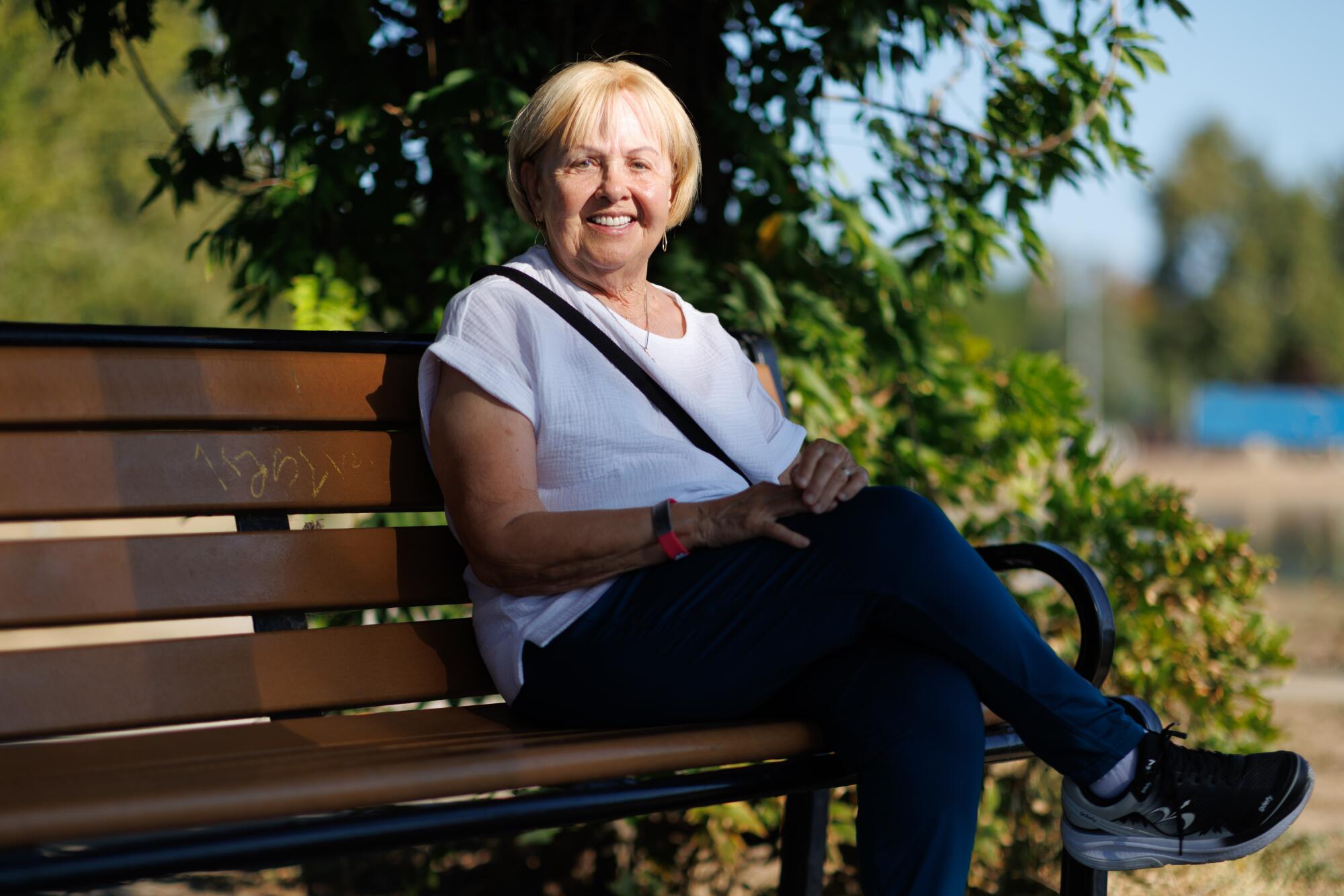 A person sits at a bench at Lake Balboa.