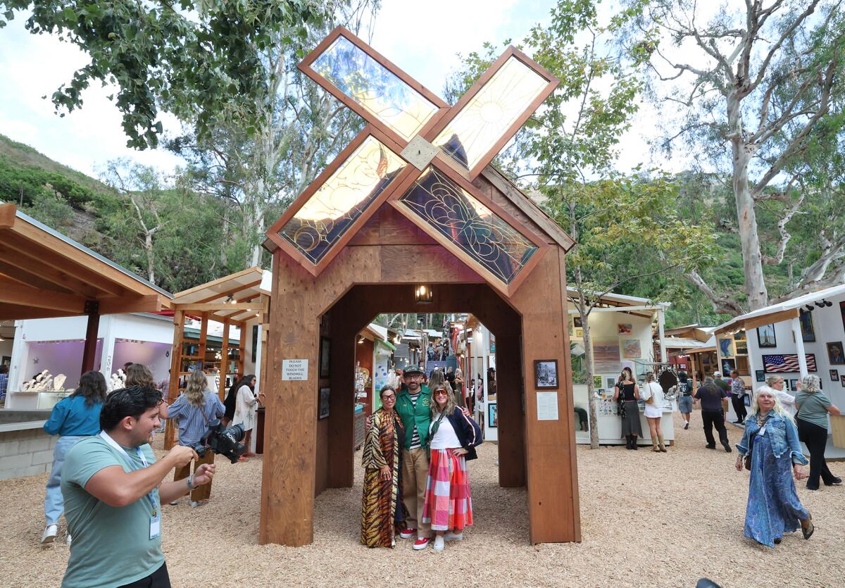 Guests stand under the replica windmill upon arrival to the 60th annual Sawdust Art Festival preview night.