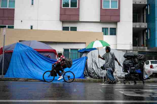 Men make their way through skid row in Los Angeles as another storm begins on Monday, February 27, 2023. (Photo by Sarah Reingewirtz, Los Angeles Daily News/SCNG)