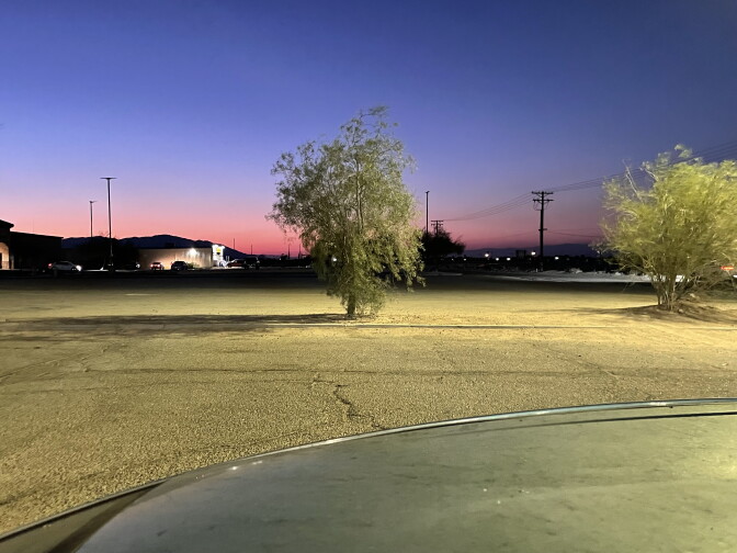 A pink and blue-hued sunset over a parking lot.