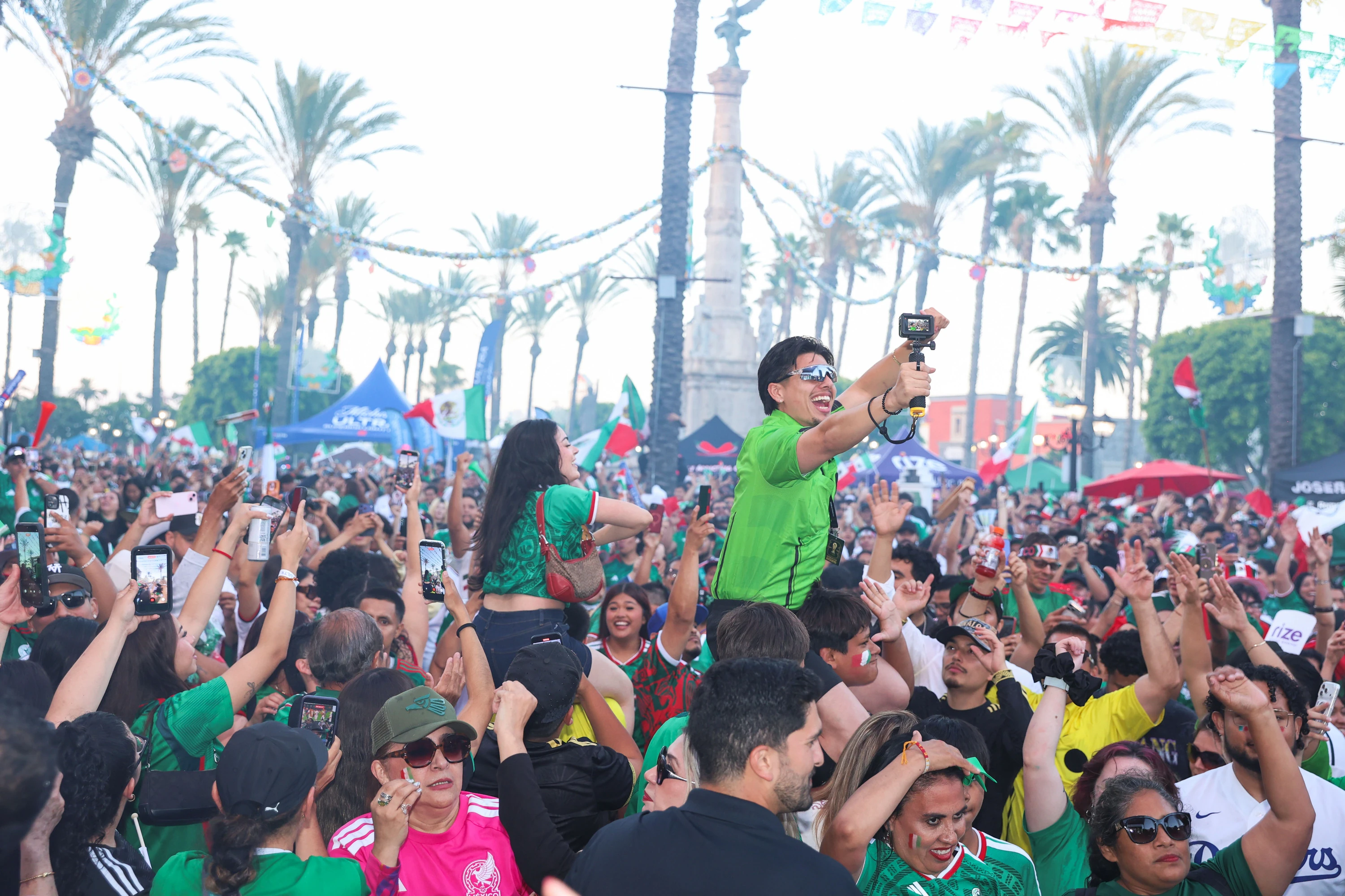 A crowd of people cheering on Mexico at a World Cup watch party.