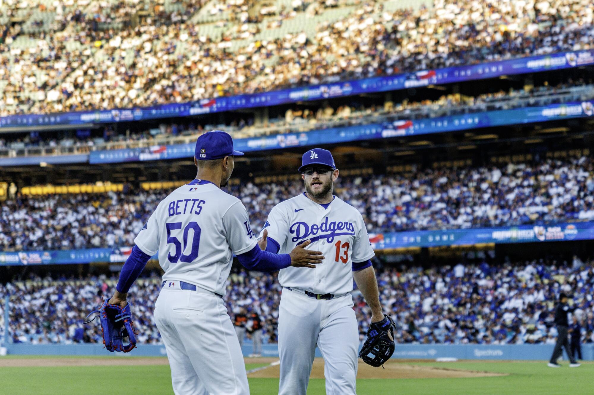Dodgers shortstop Mookie Betts, left, and third baseman Max Muncy congratulate each other after a defensive play last month.
