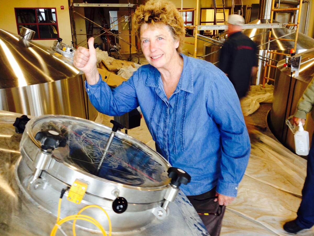 Barbara Groom checks a new brewing tank, called a mash can, at her Lost Coast Brewery in Eureka, Calif.
