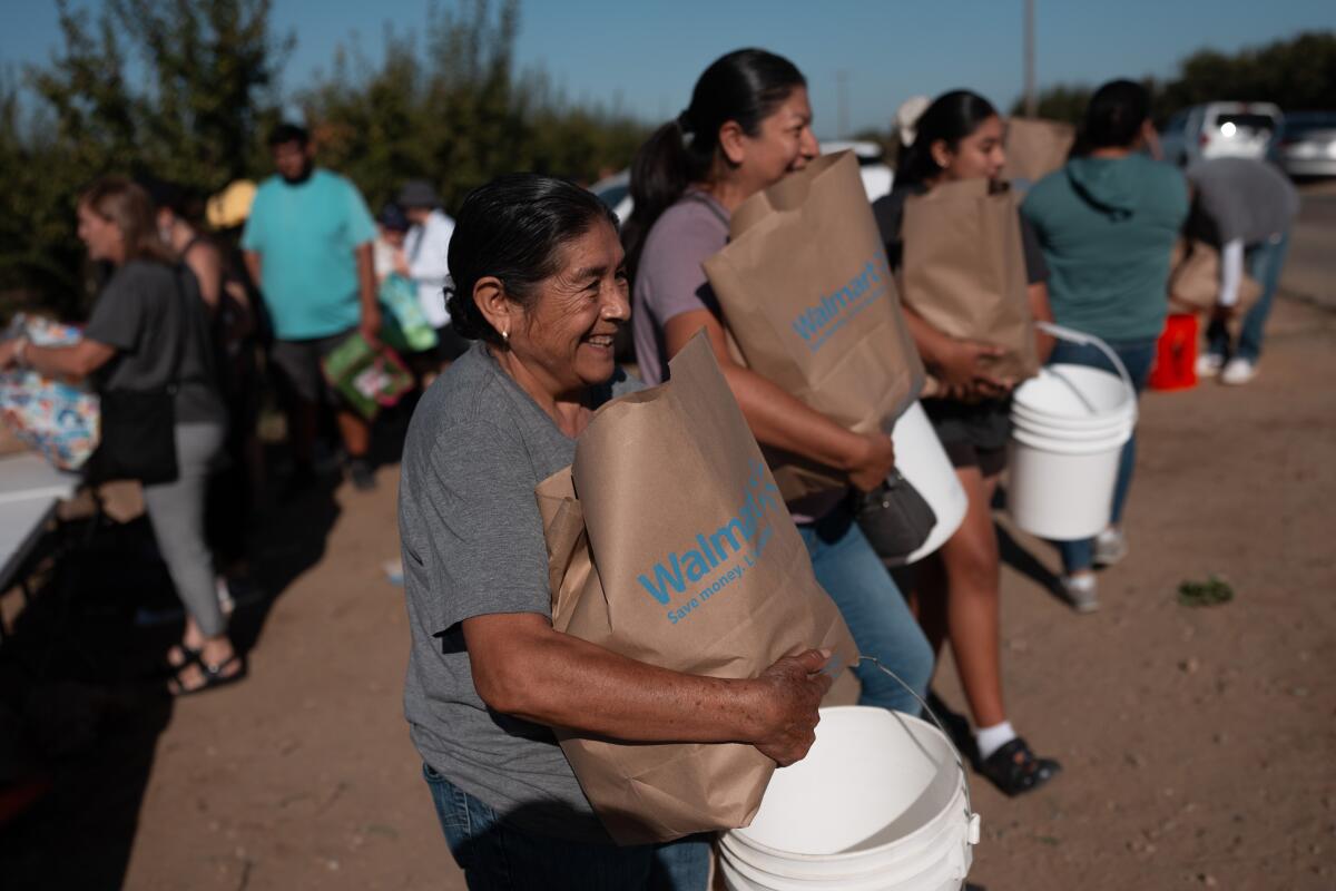Guadalupe Martinez smiles after getting a bag of nectarines.