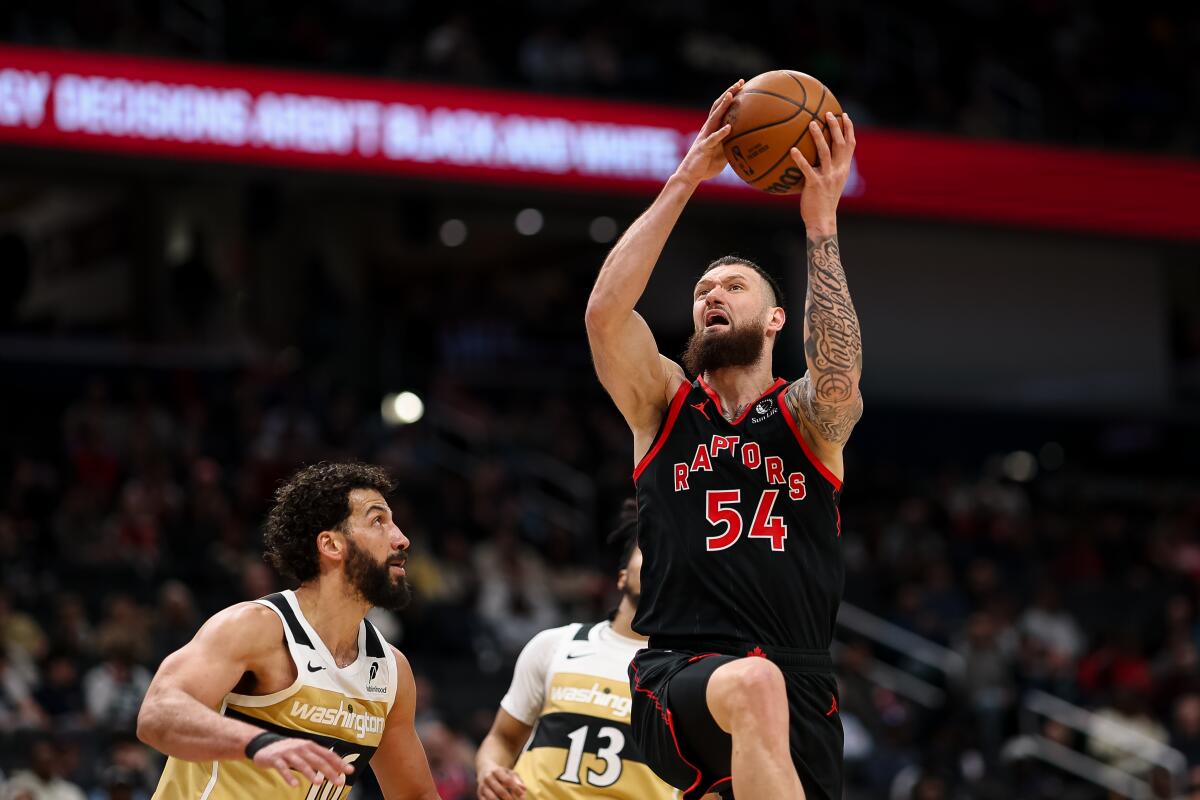 Toronto's Sandro Mamukelashvili elevates for a layup in front of Wizards forward Anthony Gill on Feb. 28 in Washington.