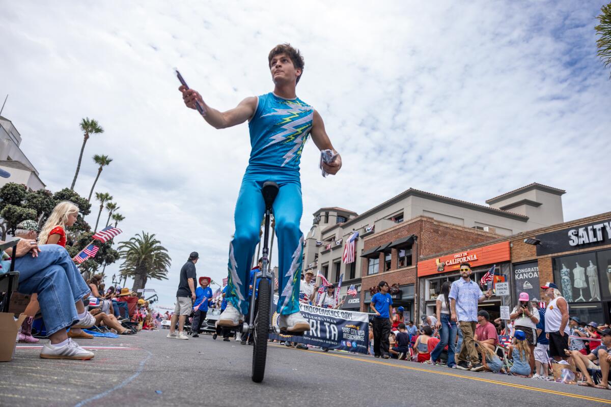 A unicycler hands out wristbands during Huntington Beach's 122nd Annual 4th of July Parade.